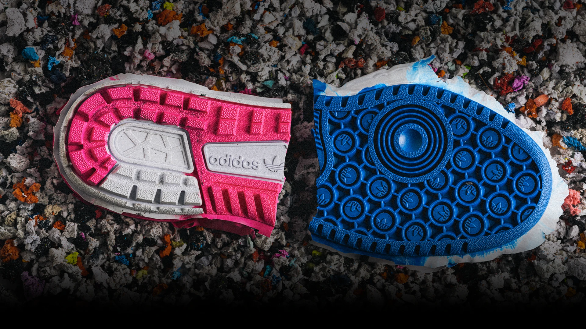 A collage image showing two different sneaker soles placed on multicolored shredded paper. The left sole is pink-colored and the right is blue.