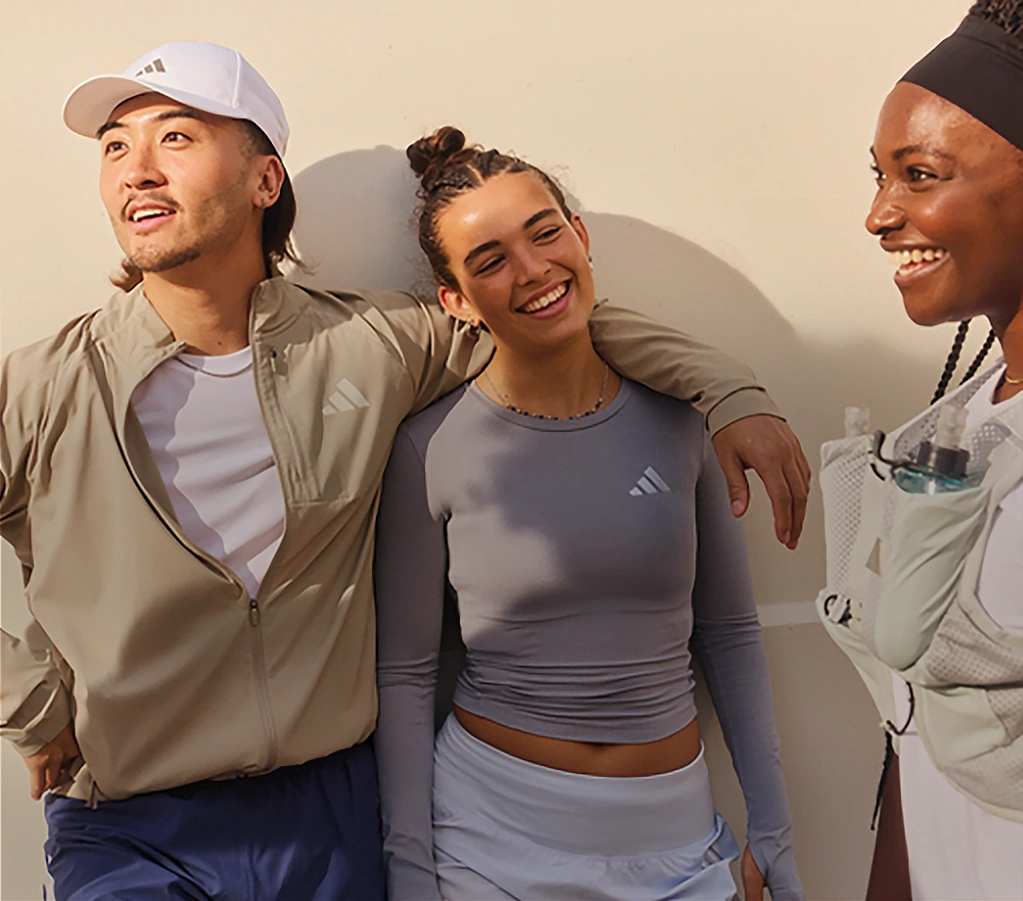 Gruppe junger Menschen in adidas Sportbekleidung im Gespräch. (Foto)