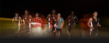 Laufgruppe trainiert nachts in adidas Laufbekleidung. (Foto)