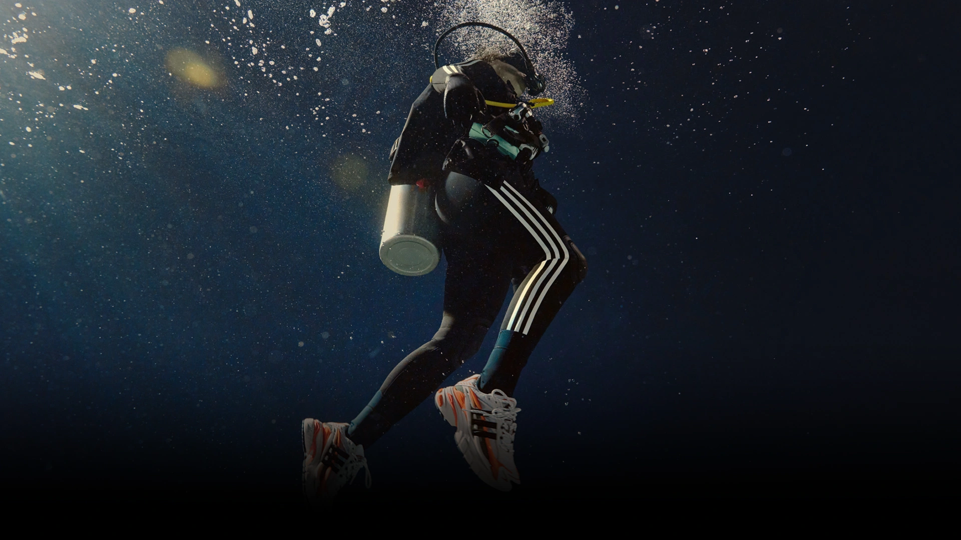 Person beim Tauchen unter Wasser mit adidas Schuhen. (Foto)