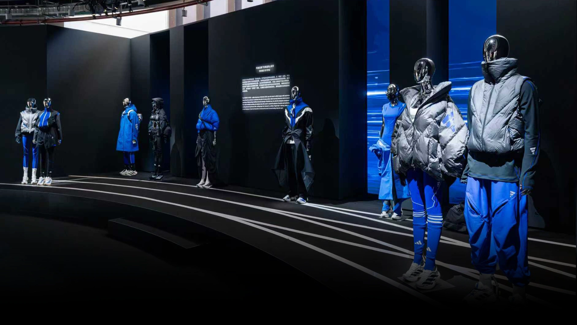 Ausstellung mit adidas Outfits auf Schaufensterpuppen in modernem Showroom. (Foto)