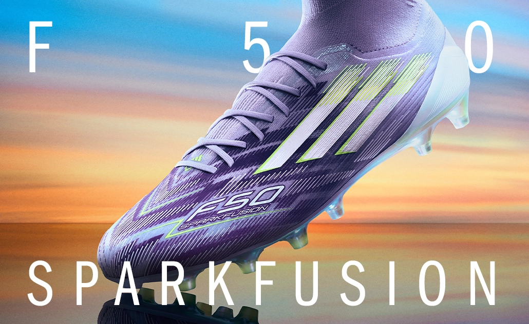 Lila adidas Fußballschuh mit hellen Streifen und Nocken vor farbigem Hintergrund, mit Schriftzug „F50 Sparkfusion“. (Foto)