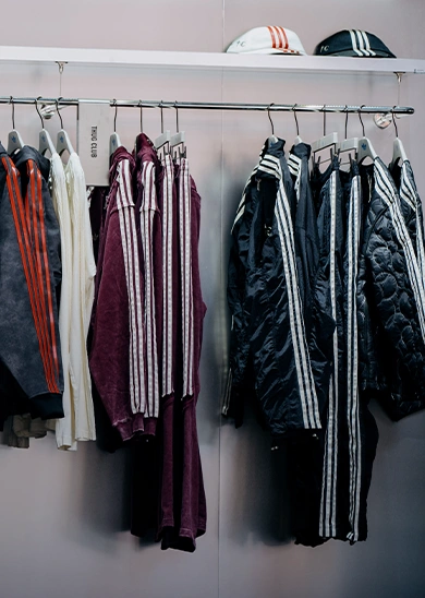 Clothing rack with adidas jackets and tracksuits. (Photo)
