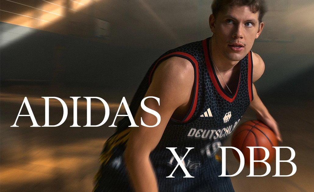 Man wearing a black adidas Germany basketball jersey dribbling a basketball, with the text “adidas x DBB.” (Photo)