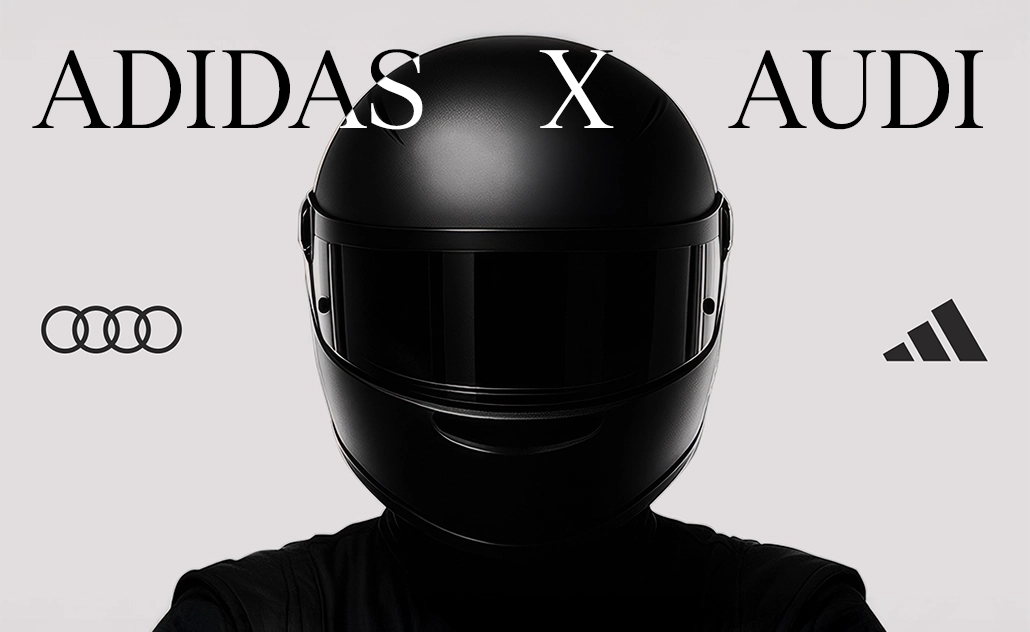 Person wearing a black racing helmet against a light background, with the text “adidas x Audi” and brand logos. (Photo)